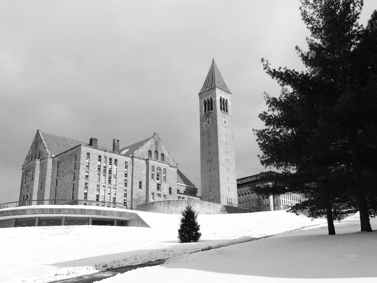 A black-and-white winter photograph of Cornell buildings and a clock tower.